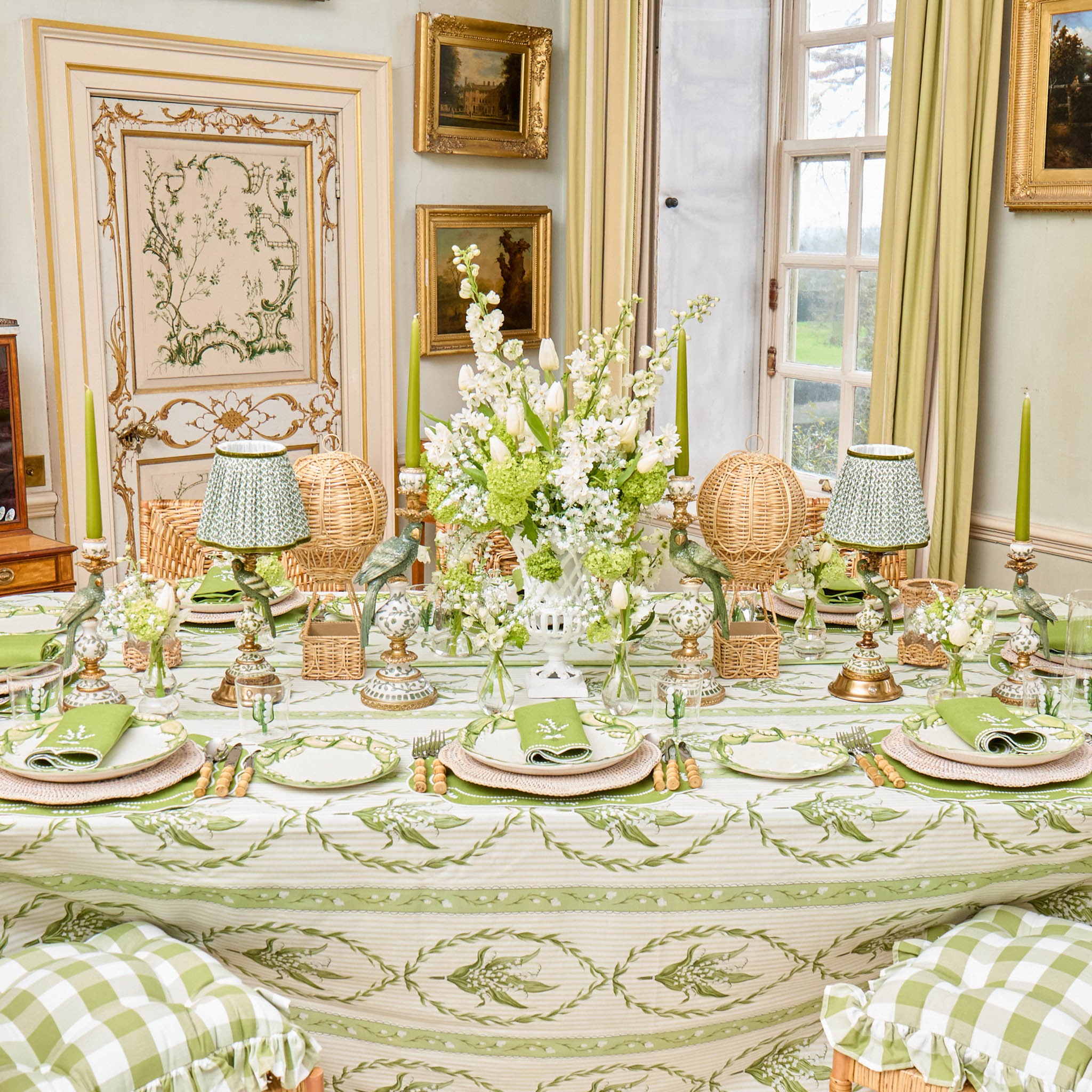 Elegant dining room with a table set for a meal, featuring green and white decor.