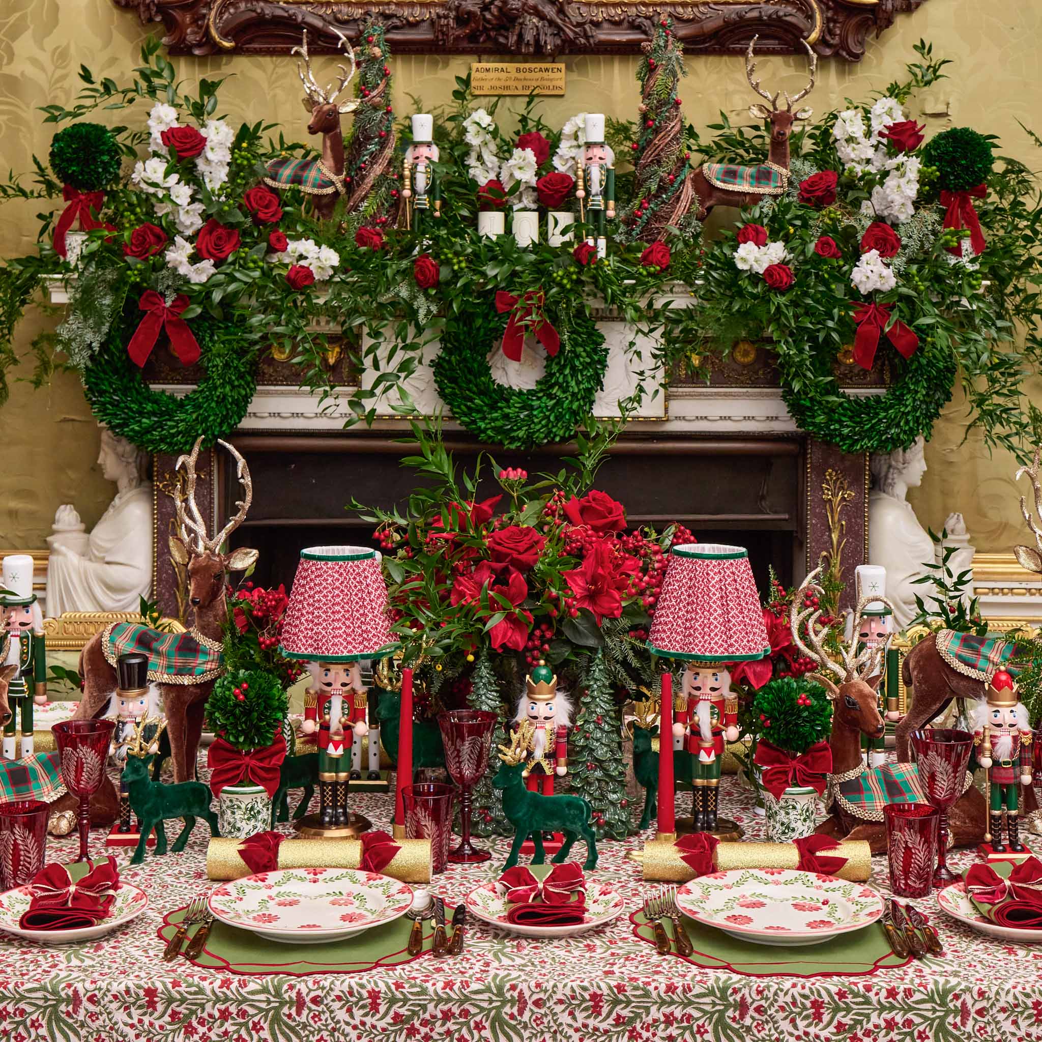 Decorative Christmas table setting with wreaths, lanterns, and nutcrackers.