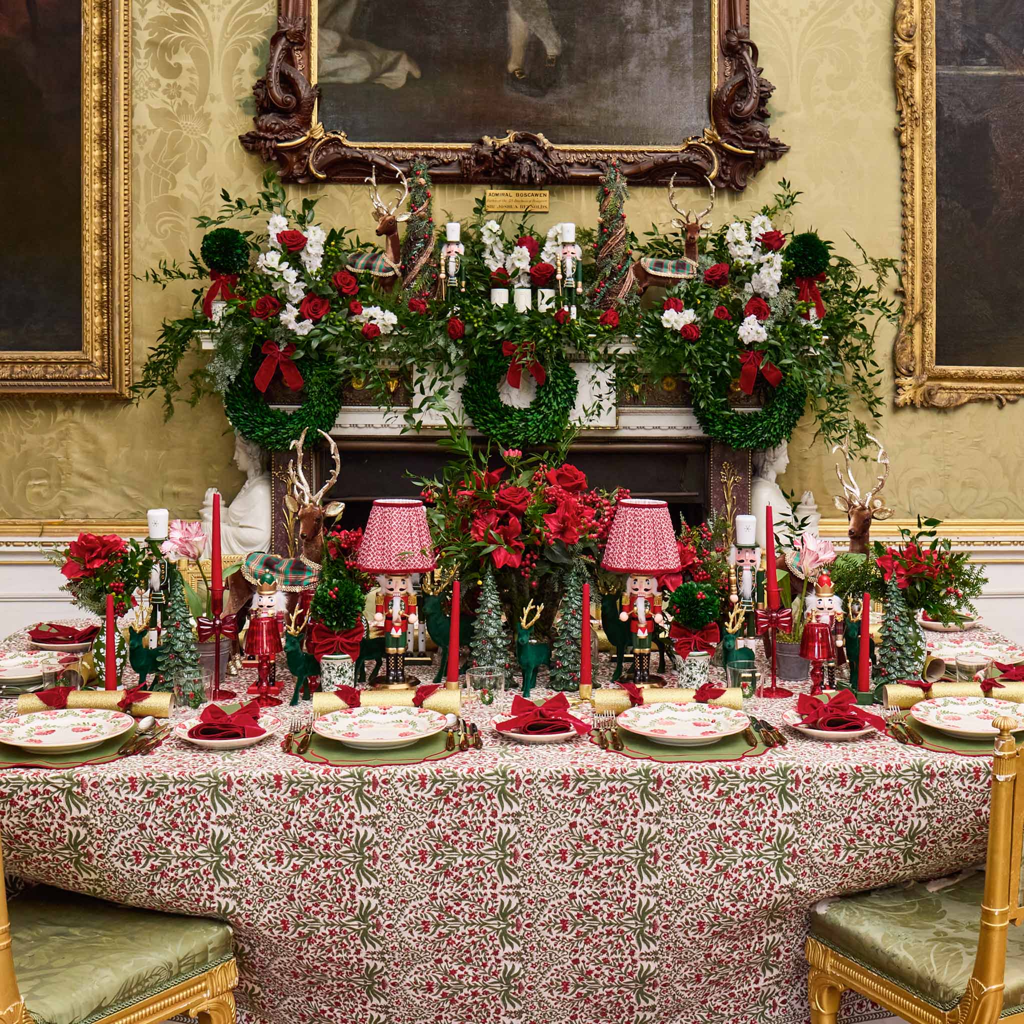Decorative Christmas table setting with floral arrangements and candles in a formal room.