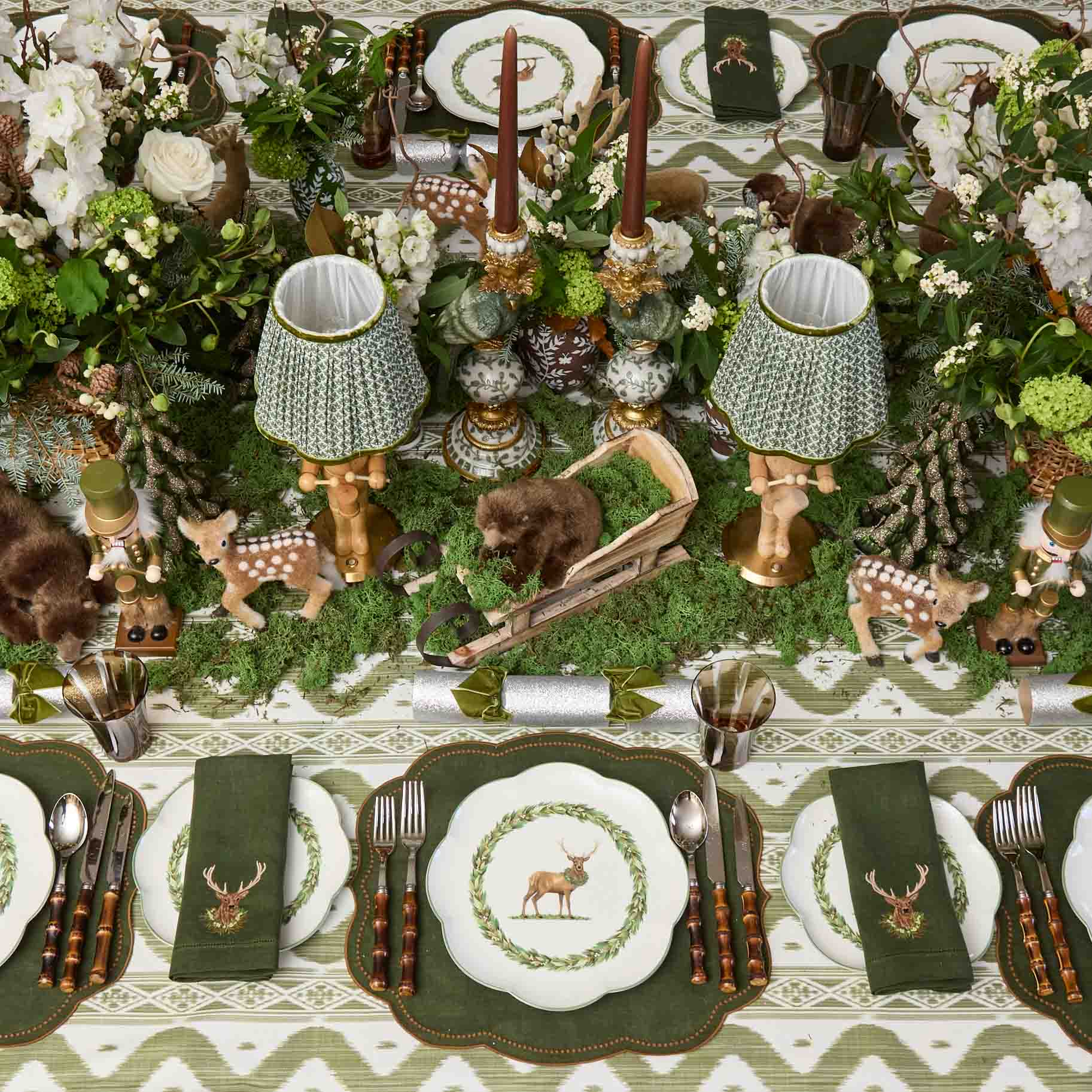 Decorative table setting with animal-themed plates, napkins, and centerpieces on a patterned tablecloth.
