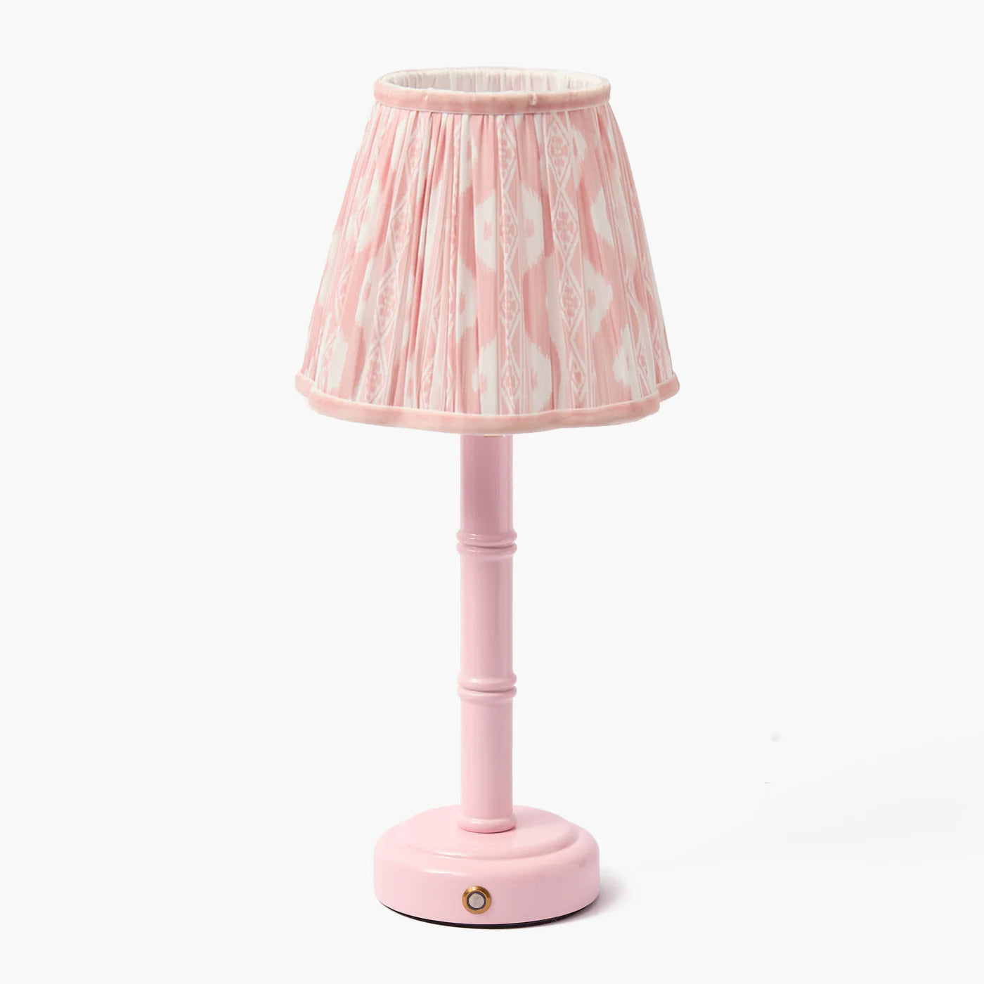 A pink lacquer rechargeable lamp with a bamboo-like design base and a pink ikat shade.