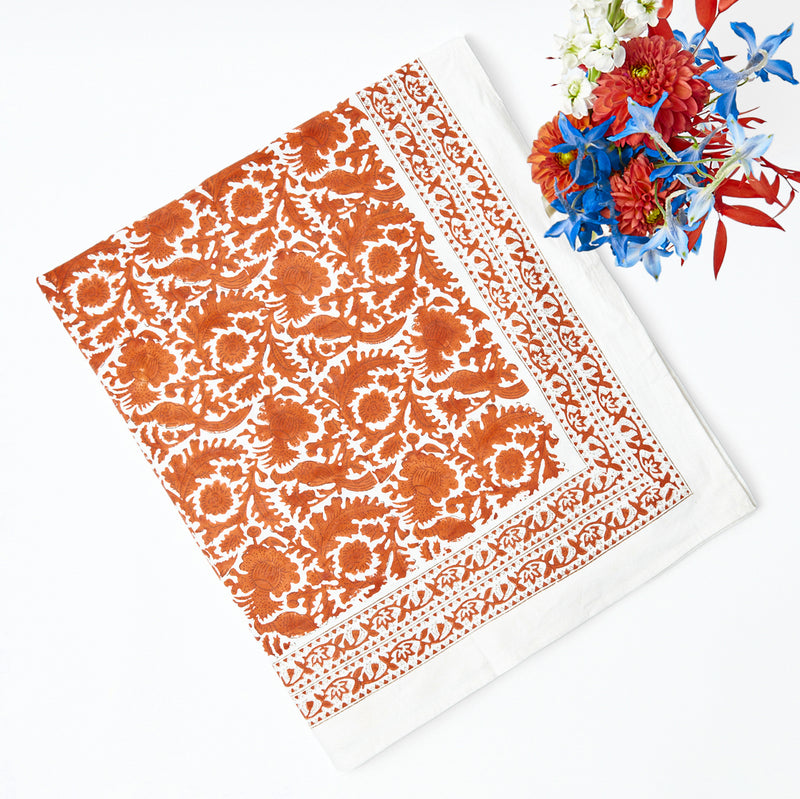 Burnt orange tablecloth adorned with charming pheasant motifs.