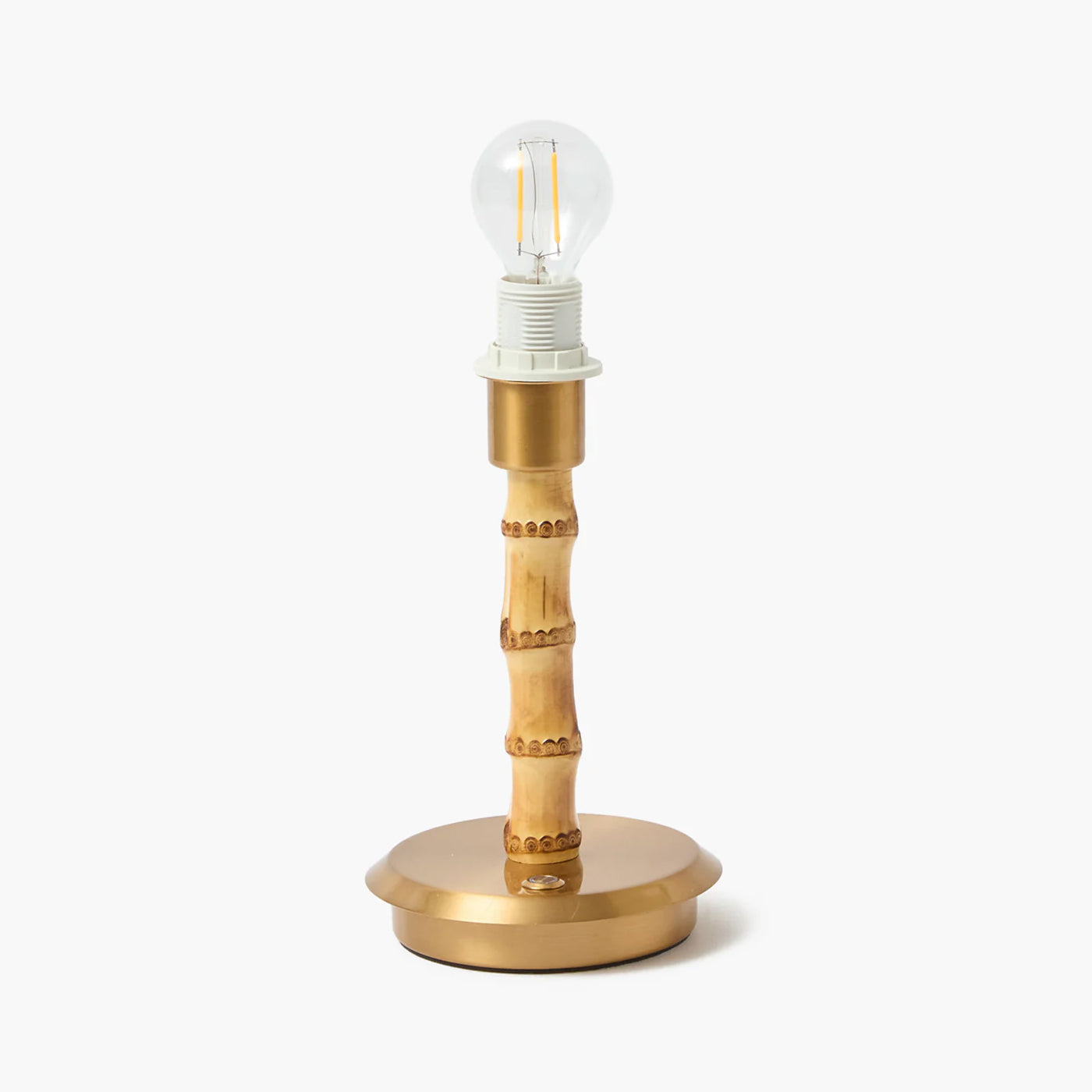 Gold table lamp with a clear light bulb on a white background