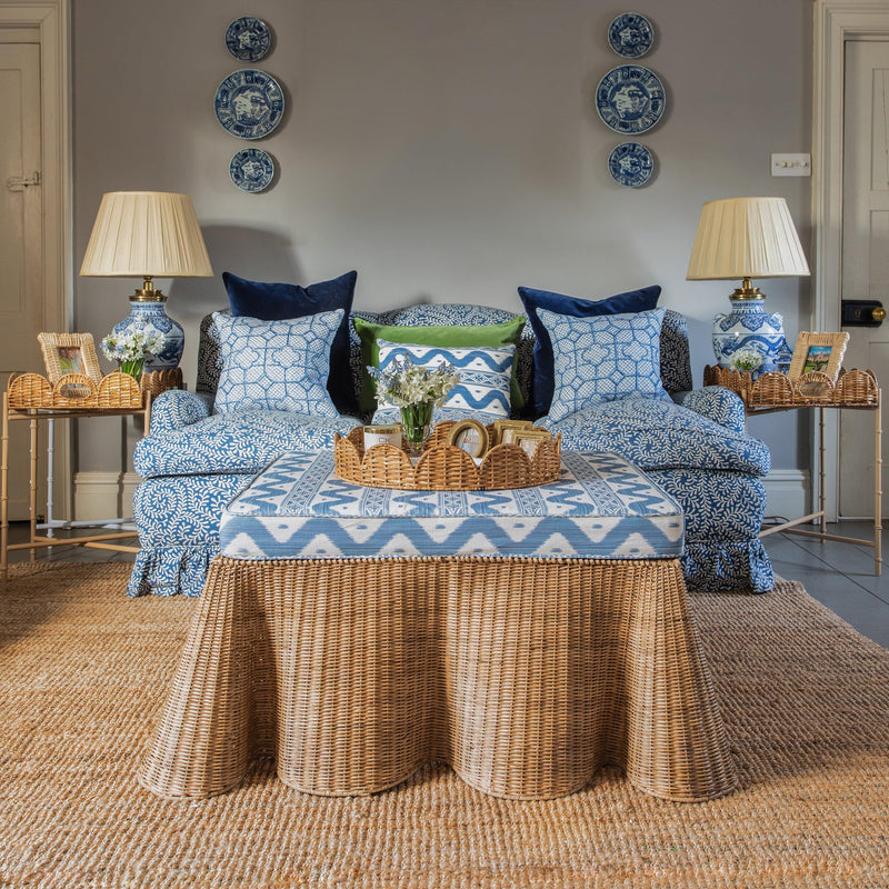 Enhance your living space with the playful and delightful Vivienne Rattan Scalloped Ottoman - a stylish choice that adds a dash of coastal elegance and an extra place to sit in your decor.