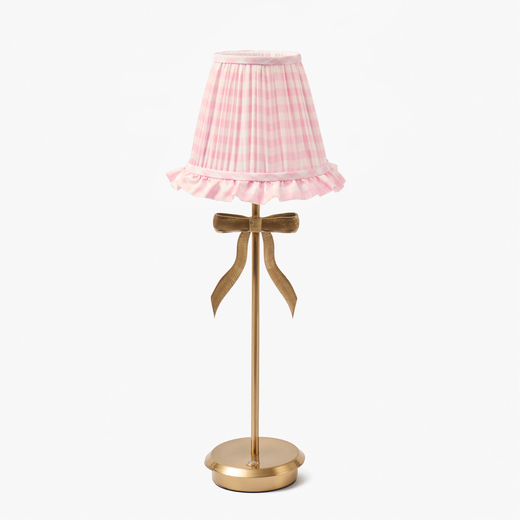 Table lamp with a pink pleated shade and gold base on a white background