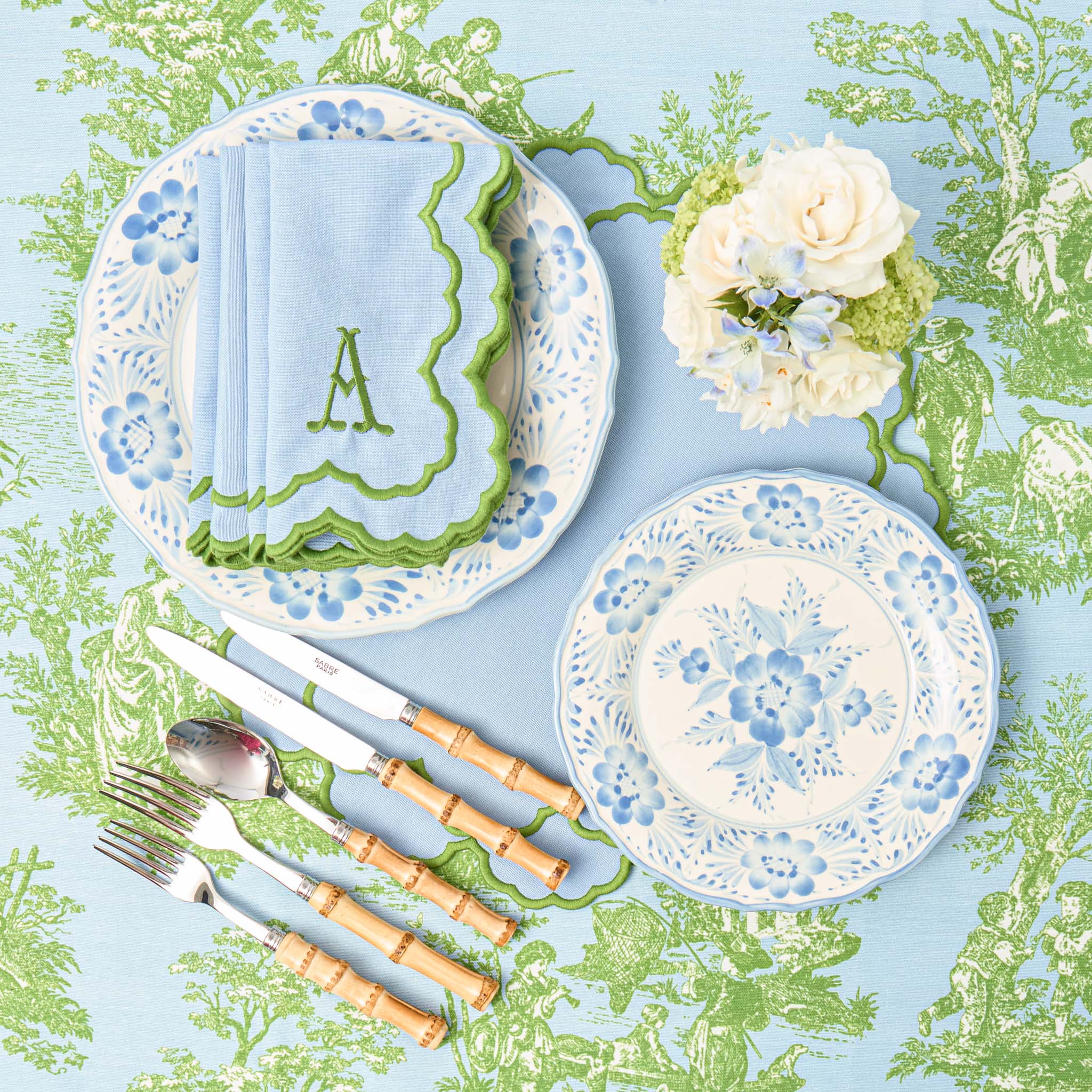 Floral-patterned plates with cutlery on a decorative tablecloth