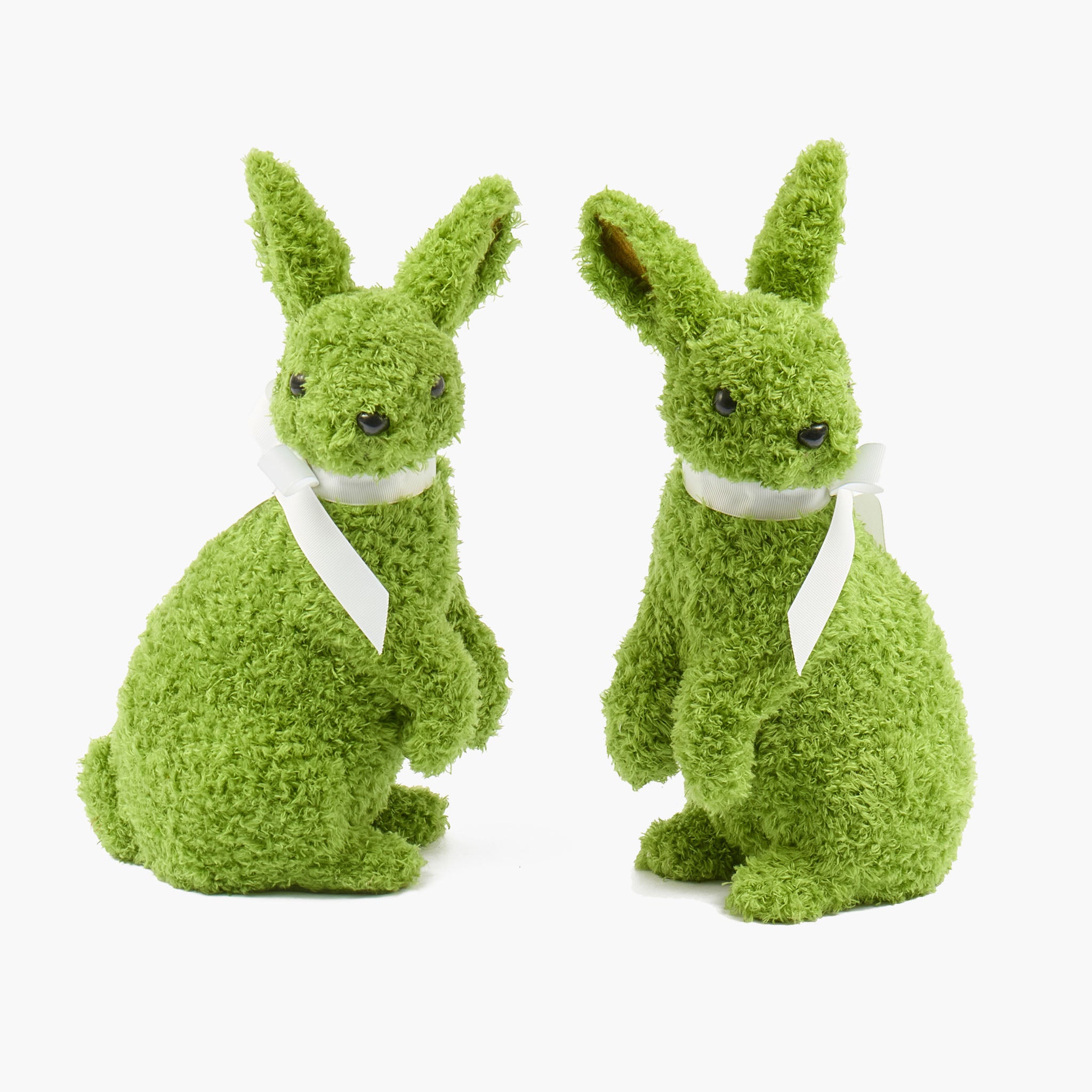 Two green rabbit figurines with white collars on a white background