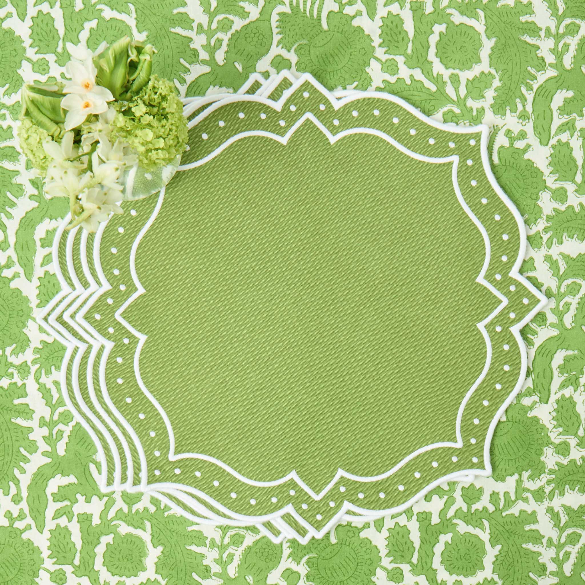 Decorative green paper with a white floral design and border on a matching green background.