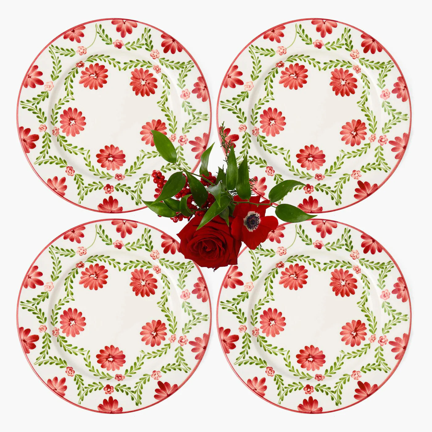 Four floral plates with red and green patterns on a white background