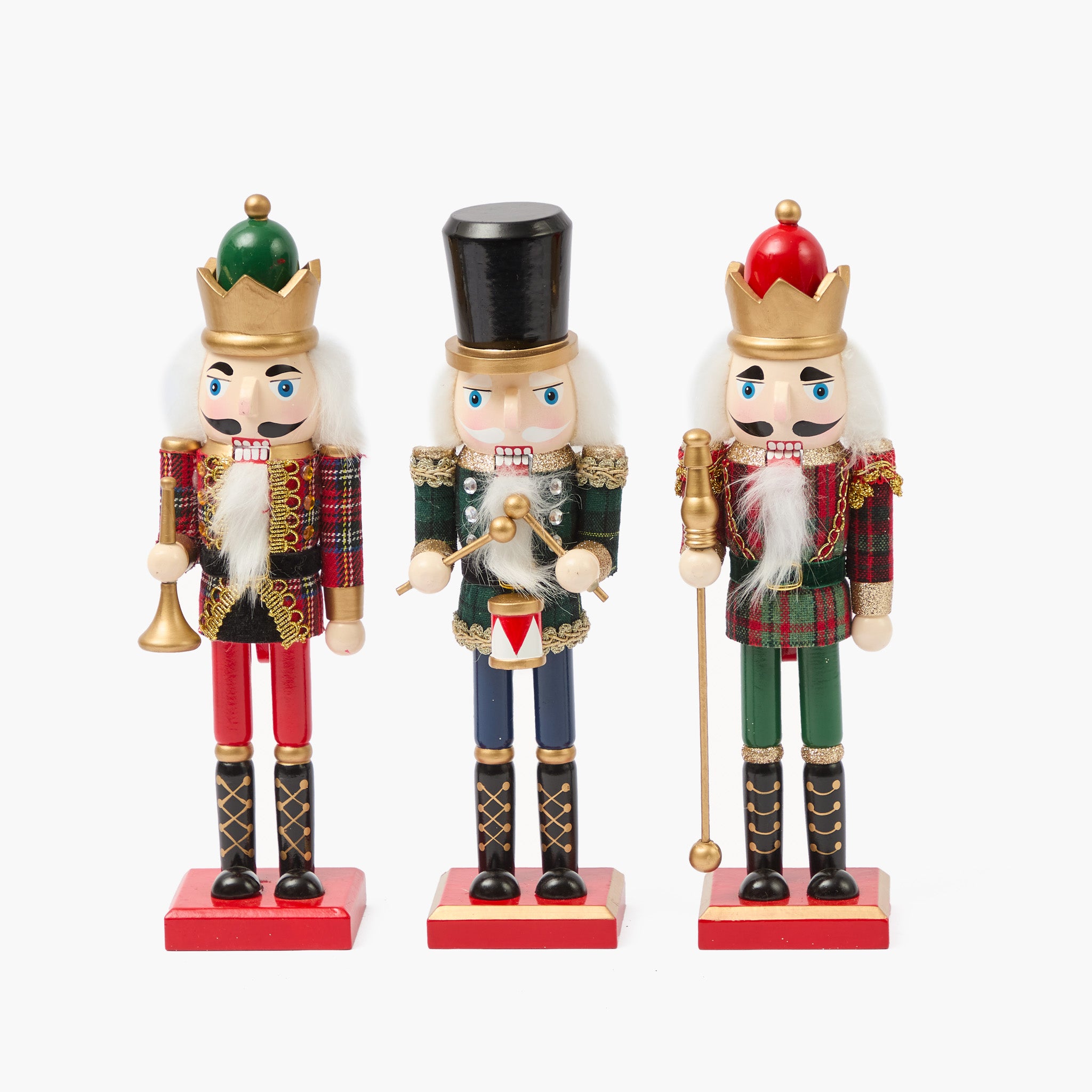 Three nutcracker figurines with different outfits on a white background
