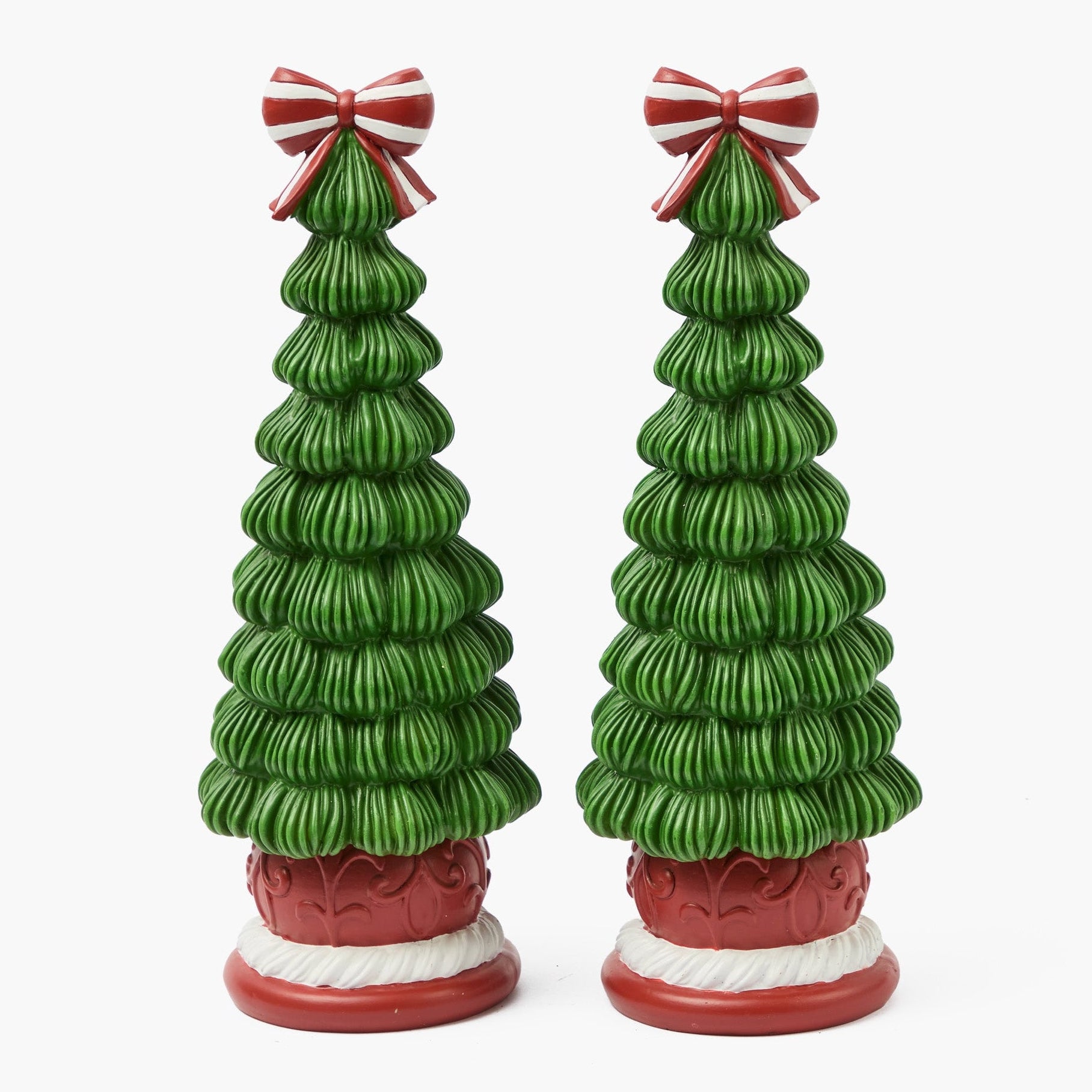 Two green ceramic Christmas trees with red bases and candy cane bows on a white background