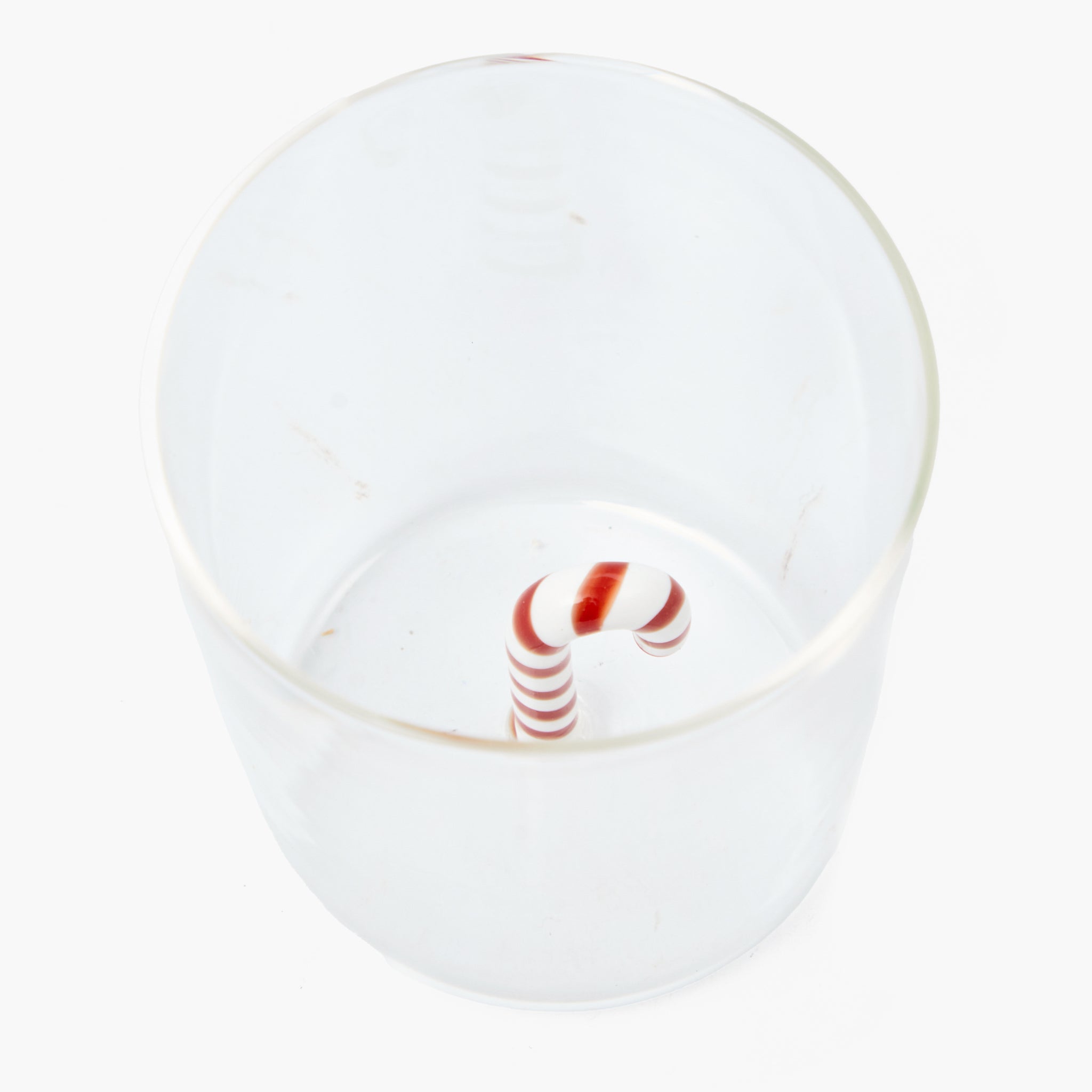 Clear glass with a red and white striped candy cane inside on a white background