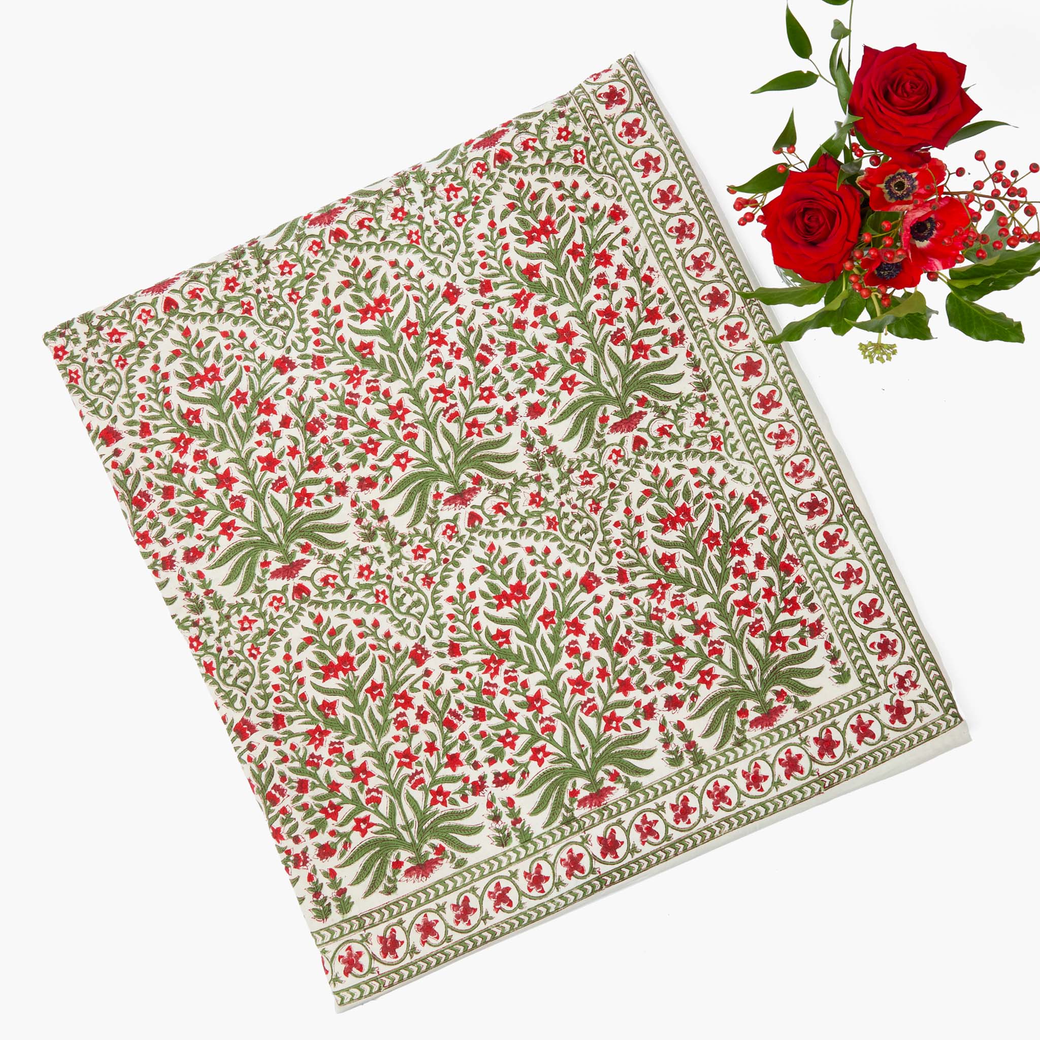 Floral patterned fabric with red flowers and green leaves on a white background