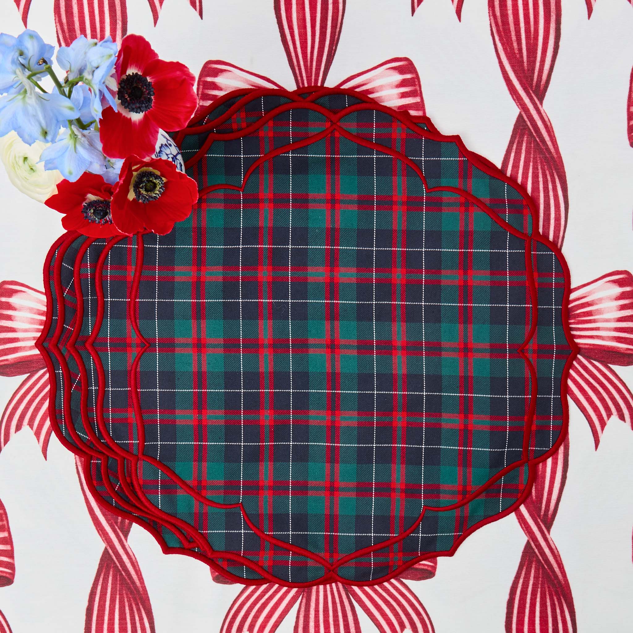 Decorative plate with red and green plaid pattern on a white background with floral elements.